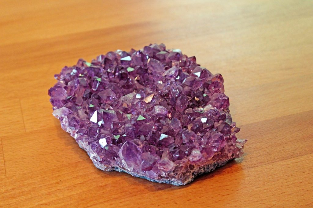 Amethyst liegt als Heilstein auf einem Tisch